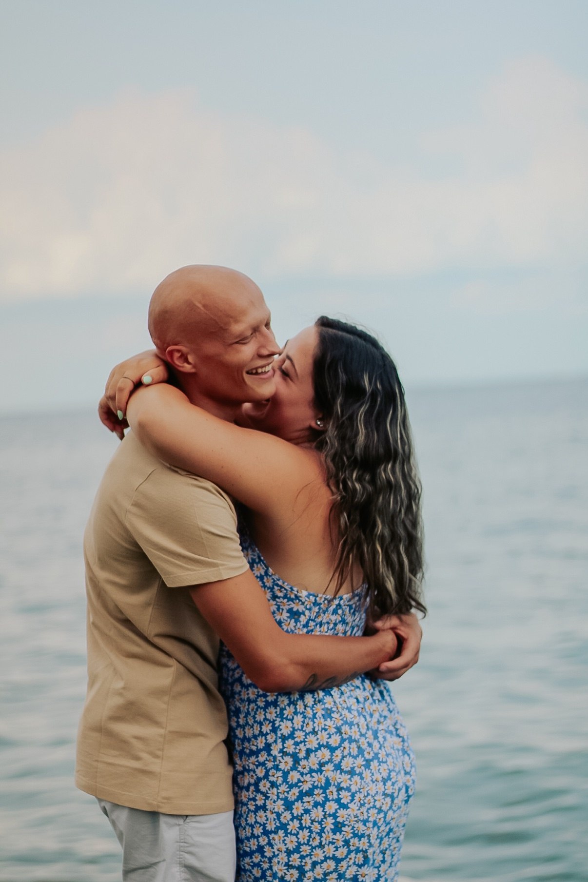 Couple hugging and laughing together by the water at a JT Photos session